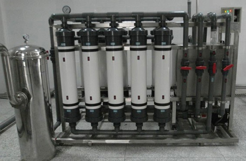 Ultrafiltration skid with five white hollow-fibre membrane modules, grey pipework and a stainless-steel pre-filter